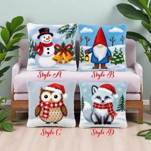 Könnte beinhalten: Vier dekorative Kissen mit Wintermotiven. Zu den Stilen gehören ein Schneemann mit schwarzem Hut, ein Zwerg mit einer Laterne, eine Eule und ein Fuchs, alle mit Winteraccessoires. Jedes Kissen hat einen hellblauen Hintergrund.