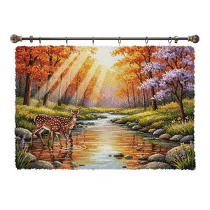 May include: A tapestry showing an autumnal forest scene with a stream and two deer drinking. The artwork uses vibrant colours of orange, yellow, and purple, with sunlight filtering through the trees. The tapestry is suspended from a decorative bronze curtain rail.