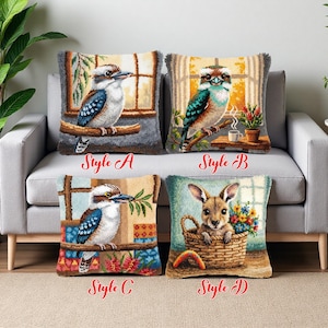 Op de afbeelding: Vier decoratieve sierkussens met geborduurde ontwerpen. Stijlen A, B en C tonen Kookaburras op takken, terwijl stijl D een kangoeroe in een mand met bloemen toont. Elk kussen heeft een getextureerde, gefranjerde rand en de stijnaam.