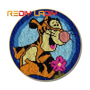 May include: A round needlepoint canvas featuring a cartoon image of Tigger from Winnie the Pooh. Tigger is orange and black with a pink nose and a flower in his paw. The background is blue with white dots.