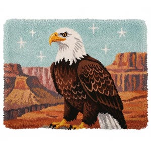 Op de afbeelding: Een handgetuft tapijt met een majestueuze Amerikaanse zeearend met een witte kop en bruin lichaam, tegen een achtergrond van een canyon en een lichtblauwe lucht met witte sterren. De arend zit op een tak, met zijn gele snavel en klauwen zichtbaar.