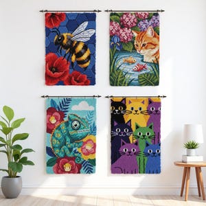 May include: Four colorful, framed wall hangings. One features a bee with red poppies, another a cat by a pond with fish, a third a chameleon with flowers, and the last, a group of cats in various colors. Each is mounted on a white wall.