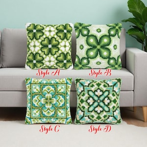 Könnte beinhalten: Vier dekorative Kissen mit grün-weißen Blumenmustern werden auf einem grauen Sofa präsentiert. Die Kissen sind mit Style A, B, C und D beschriftet. Die Kissen haben ein strukturiertes, getuftetes Aussehen.