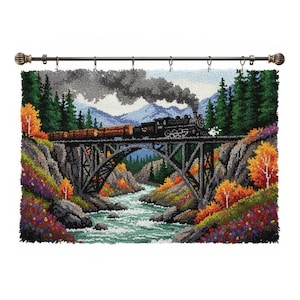 Puede incluir: Un tapiz de pared textil detallado que representa un tren de vapor negro que cruza un puente sobre un río. La escena incluye follaje colorido, montañas y un cielo gris oscuro. La barra de cortina es de bronce.