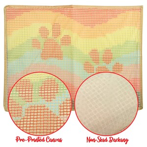 May include: A close-up of a pre-printed canvas with a rainbow design and paw prints. The canvas has a non-skid backing.