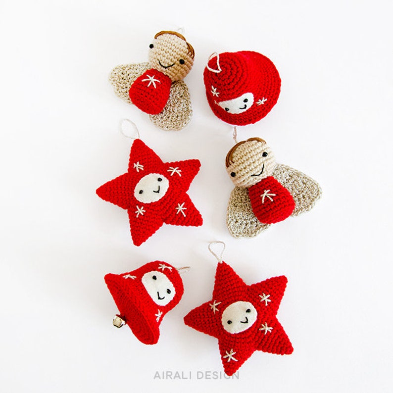 Pode incluir: Uma cole&ccedil;&atilde;o de enfeites de Natal feitos &agrave; m&atilde;o em croch&ecirc; nas cores vermelho, bege e marrom. Os enfeites incluem estrelas, sinos e figuras de anjos, cada um com um rosto sorridente e detalhes bordados em branco. Design l&uacute;dico e festivo.