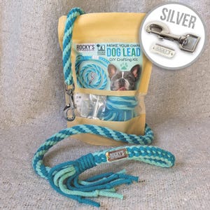 May include: A DIY dog lead crafting kit with a turquoise and green rope, a silver clasp, and instructions. The kit comes in a clear plastic bag with a brown paper backing. The packaging features the text "Make Your Own Dog Lead DIY Crafting Kit".