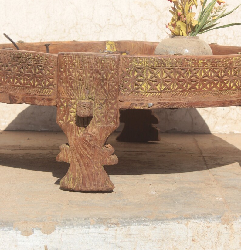 Pu&ograve; includere: Un tavolo rotondo in legno con intagli intricati e una finitura di vernice gialla. Il tavolo ha tre gambe con dettagli decorativi ed &egrave; realizzato in legno riciclato.
