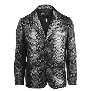 Könnte beinhalten: Ein Blazer mit Schlangenmuster in Grau- und Schwarztönen. Die Jacke hat ein fallendes Revers, zwei Vordertaschen und einen Zwei-Knopf-Verschluss. Das Futter ist schwarz, und das Etikett in der Jacke trägt die Buchstaben "CF".