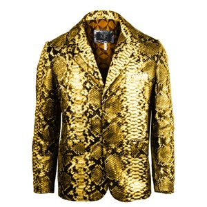 Pode incluir: Um blazer de couro de cobra dourado com fecho de botão e uma etiqueta que diz "CF".