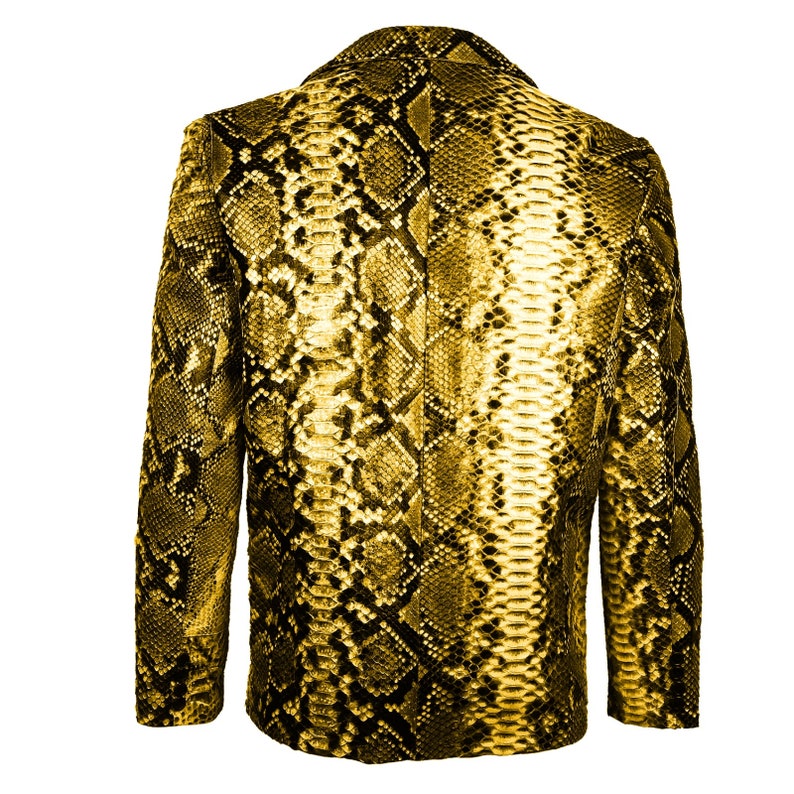 Op de afbeelding: Een gele slangenleren blazer met een klassiek dubbelrijg ontwerp. De blazer heeft een textuur, een gepatenteerd materiaal dat lijkt op slangenhuid.