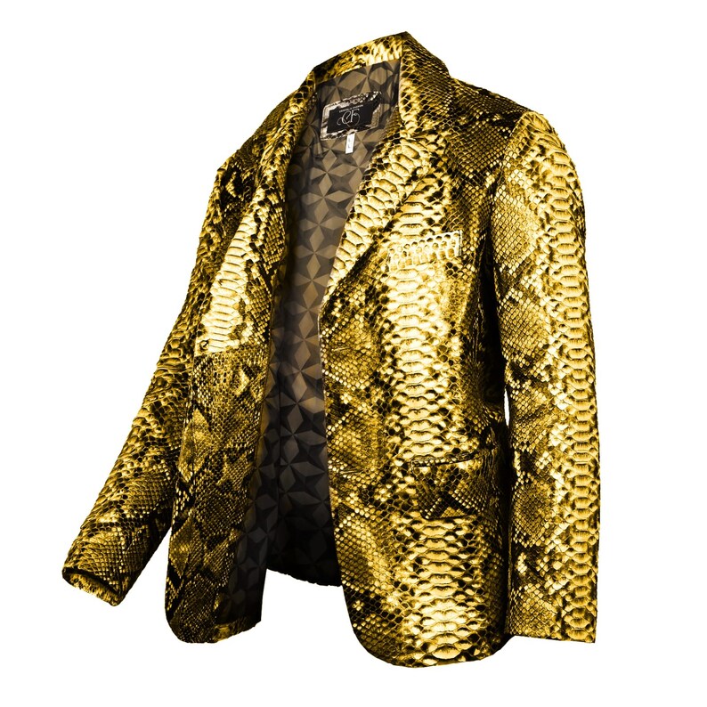 Op de afbeelding: Een gouden slangenleren blazer met een zwarte voering. De blazer heeft een klassieke snit met een revers en een knoopsluiting met twee knopen.