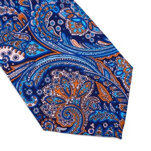 May include: A blue, orange, and white paisley patterned tie. The tie has a pointed end and is made of a silky fabric.