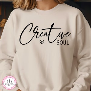 May include: White sweatshirt with the text "Creative Soul" in black script font with a small heart symbol.