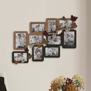 Puede incluir: Un collage de fotos enmarcadas con un acabado de madera rústica, que presenta imágenes de personas y paisajes. Los marcos están dispuestos en un patrón escalonado en una pared blanca, con mariposas decorativas adheridas a los marcos.