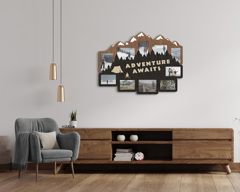 May include: A wooden photo frame with a mountain silhouette design and the text "Adventure Awaits". The frame has multiple openings for photos and is displayed on a wall above a wooden entertainment center.