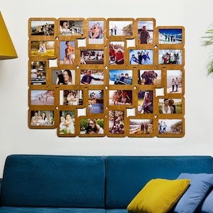 Peut inclure: Un cadre photo multiple en bois avec de nombreuses ouvertures carrées, chacune contenant une photographie différente. Le cadre est monté sur un mur blanc au-dessus d'un canapé bleu. Les photos représentent diverses personnes et scènes.