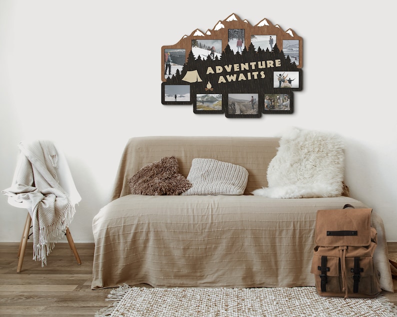 May include: A wooden photo frame with a mountain silhouette design and the text "Adventure Awaits". The frame has multiple openings for photos and is displayed on a wall above a couch.