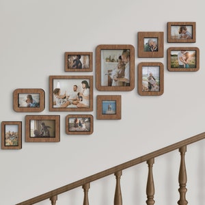 May include: A wall gallery of 11 brown wooden picture frames with various family photos. The frames are arranged in a staggered pattern, creating a visually appealing display. The frames are all the same style and color, with a simple, modern design.