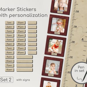 May include: A wooden growth chart with a ruler design, photo frames, and marker stickers. The chart includes the text "Marker Stickers with personalization" and "Set 2 with signs". A pen is included.