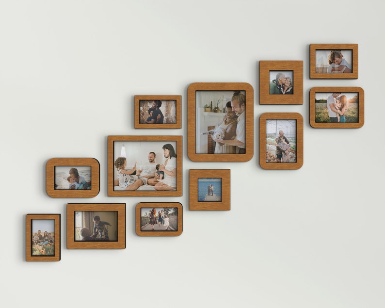 K&ouml;nnte beinhalten: Eine Anordnung von Holzbilderrahmen in verschiedenen Gr&ouml;&szlig;en an einer wei&szlig;en Wand. Die Rahmen enthalten Fotos und bilden eine Galeriewand. Die Rahmen haben eine warme, nat&uuml;rliche Holzoberfl&auml;che.