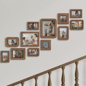 K&ouml;nnte beinhalten: Eine Ansammlung von Holzbilderrahmen in verschiedenen Gr&ouml;&szlig;en und Formen, die an einer wei&szlig;en Wand angebracht sind. Die Rahmen enthalten Fotos von Menschen und Szenen. Die Rahmen sind warmbraun und in einem versetzten Muster angeordnet.