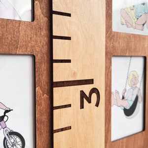May include: A wooden growth chart with a brown frame and a light wood background. The chart has a ruler with markings and the number "3" printed on it. There are also picture frames on the chart.
