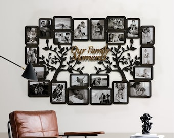 May include: Black wooden photo frame with a tree design and multiple openings for pictures. The frame has the words "Our Family Moments" in brown lettering.