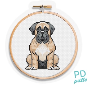 May include: A cross-stitch pattern of a brown and black bulldog sitting on a white background. The pattern is in a wooden embroidery hoop.