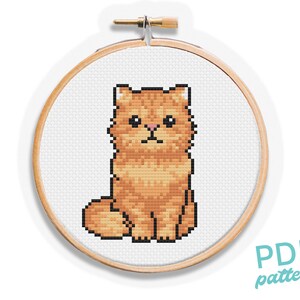 May include: A cross-stitch pattern of a fluffy orange cat sitting upright, framed in a wooden embroidery hoop. The cat is rendered in pixelated style. The words "PDF pattern" are in a teal script font.