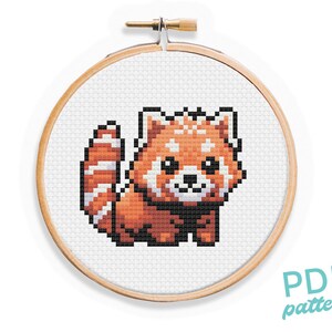 Könnte beinhalten: Ein Kreuzstichmuster mit einem Roten Panda mit einem weißen Streifen am Schwanz. Das Muster ist auf einem hölzernen Stickrahmen dargestellt. Der Text "PDF pattern" ist in der rechten unteren Ecke des Bildes zu sehen.