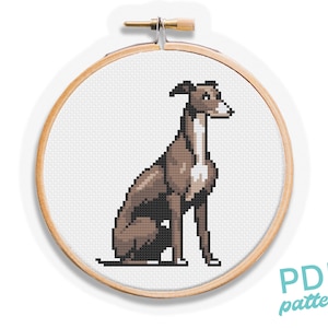 May include: A cross-stitch design of a greyhound dog in a wooden embroidery hoop. The dog is brown and white, with a pixelated design. The text "PDF pattern" is in the lower right corner.