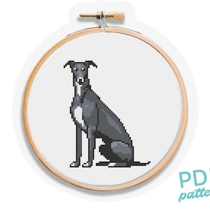 May include: A cross-stitch pattern of a greyhound dog in a wooden embroidery hoop. The dog is depicted in shades of grey and white, with a pixelated design. The text "PDF pattern" is in the lower right corner.