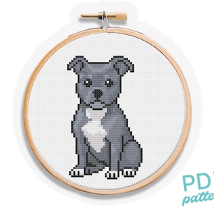 Puede incluir: Un patrón de punto de cruz de un perro pitbull gris y blanco sentado, exhibido en un aro de bordado de madera. El diseño pixelado muestra las palabras "PDF pattern" en la esquina inferior derecha.