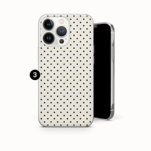 May include: A phone case featuring a cream-colored background with a repeating pattern of small black polka dots. The case has a cutout for a triple-lens camera system on the back. A black circle with the number 3 is positioned on the left side.