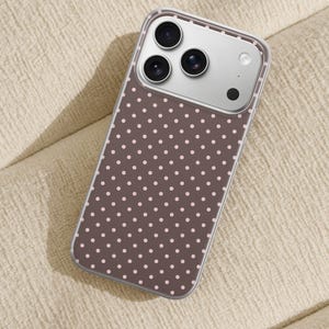 May include: A smartphone case featuring a dark brown background with a repeating pattern of small, light pink polka dots. The case is transparent around the edges and includes a rectangular cutout for the camera lenses and flash module.