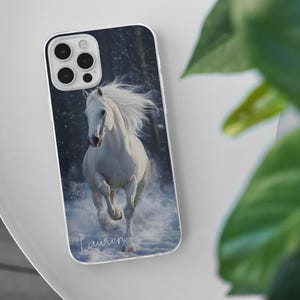 May include: A phone case featuring a white horse running through snow. The image has a winter theme with a dark background. The name "Lauren" is written in cursive at the bottom of the case.