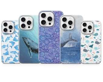 Puede incluir: Cinco fundas para teléfono con diseños temáticos del océano. Las fundas presentan imágenes de ballenas, delfines y otra vida marina en tonos azules y blancos. Una funda tiene la palabra "OCEAN" impresa.