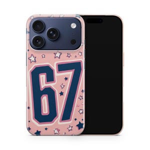 Könnte beinhalten: Ein Handycase mit der Zahl 67 in Marineblau mit weißer Umrandung auf rosa Hintergrund. Das Case ist mit weißen und marineblauen Sternen verziert. Das Handycase liegt auf einem schwarzen Handy.