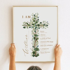 May include: A framed print featuring a watercolour illustration of a cross formed from green leaves and blue flowers. The text "I AM" is at the top of the print, and the name "William" is written in cursive on the left side. The print includes a list of positive affirmations, such as "brave", "chosen", and "loved forever", each with a corresponding Bible verse.