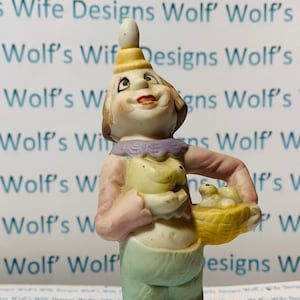 Niedliche kleine Figur mit Küken und Ei auf dem Kopf. Porzellan Figur vielleicht Porzellan Clown niedliche Oster Dekoration.