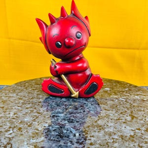 Porcelain little devil or ceramic little devil figurine marked Lille j. on the bottom and has faded back for being left in a windowsill