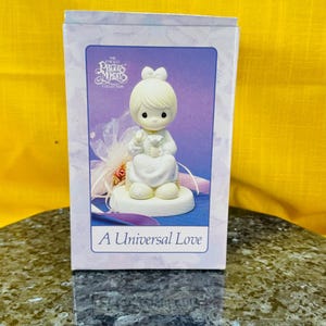 Una figura de porcelana Precious Moments de Universal Love en caja con todas las tarjetas y documentación incluidas #527173