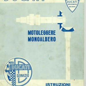May include: Vintage Ducati motorcycle service manual cover. The cover is light blue with white text and illustrations. The Ducati logo is at the top, with the text "MOTOLEGGERE MONOALBERO" and "ISTRUZIONI PER LE STAZIONI DI SERVIZIO".