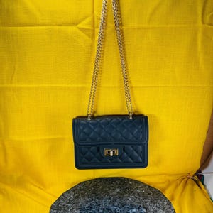 quilted style shoulder bag with gold color heavy chain straps nice quality has actual screws holding it together purse