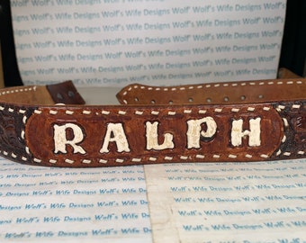 Tooled leather belt with the name Ralph plastic cording done but not well inside is just poking out also belt has wear see photos