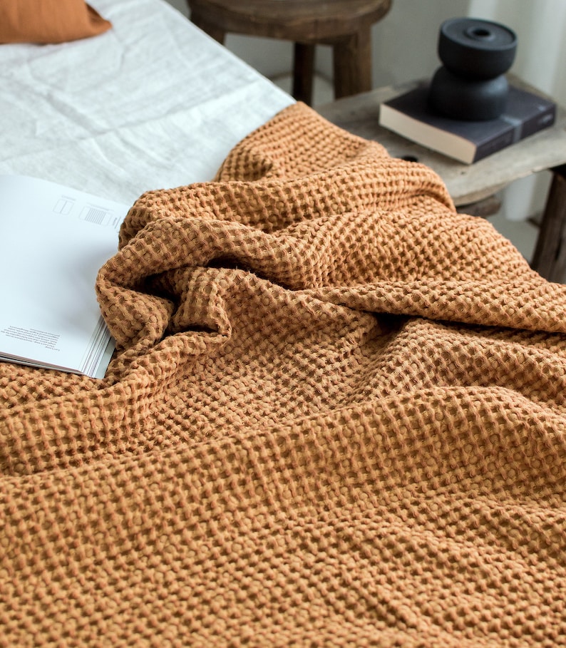 Pu&ograve; includere: Una coperta in tessuto a nido d'ape di colore marrone caldo. La coperta &egrave; realizzata in un tessuto morbido e testurizzato, perfetta per aggiungere un tocco di calore e comfort a qualsiasi ambiente.