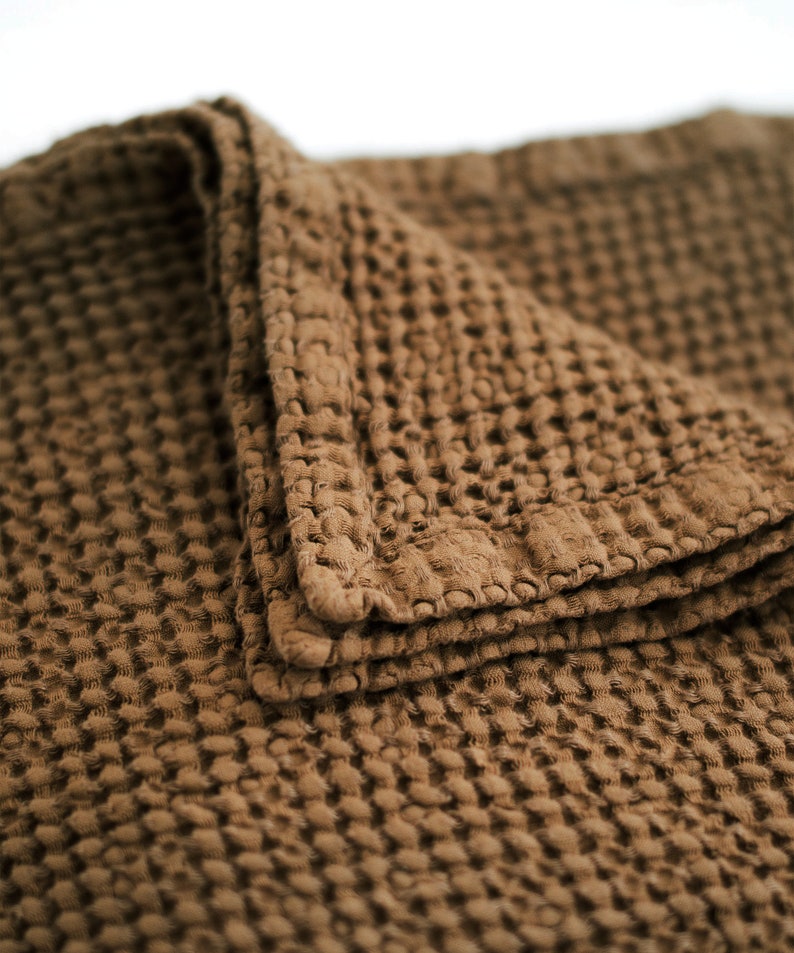 May include: A brown waffle weave throw blanket with a textured surface.