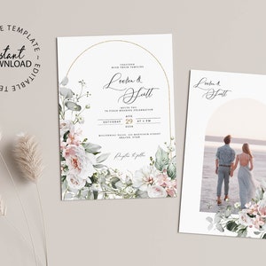 May include: Two wedding invitations with a floral design. The first invitation features a white and green floral wreath with a gold arch and the text "Lorien & Scott". The second invitation features a photo of a couple standing on a beach with a white and green floral wreath around the photo.
