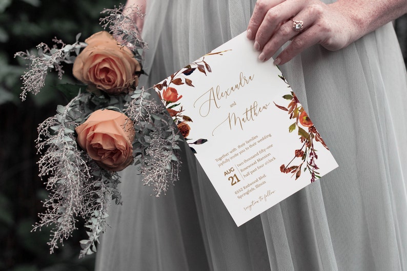 May include: A wedding invitation with a floral design in shades of orange, red, and brown. The invitation reads "Alexandra and Matthew" with the date "August 21" and the time "half past four o'clock".